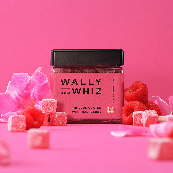 Wally & Whiz Hibiscus vingummi vendt i Hindbær-pulver Smagen er pink! Den let syrlige smag af hibiscus komplementeres af den fine smag af søde hindbær. Dette er hurtigt blevet en sommer favorit hos os! En blanding mellem sydens sol og sommerferie, og den danske sensommer med dens overmodne hindbær, lige til at plukke. Det er et møde mellem det bedste fra to verdener - Det pæredanske og det eksotiske.